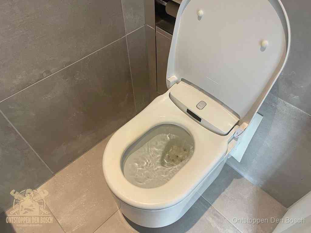 Een toiletpot vol troebel water met drijvend papier en restanten, de meest voorkomende oorzaak van een verstopte wc in Den Bosch