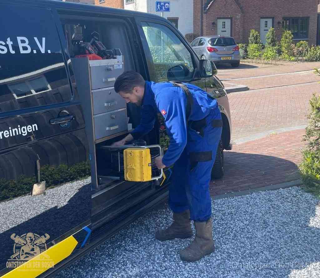 Een monteur pakt apparatuur uit de bedrijfsbus voor service aan huis, het moment om een professional in te schakelen voor een verstopte wc in Den Bosch